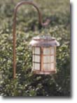 Picture of a copper solar light in a garden.